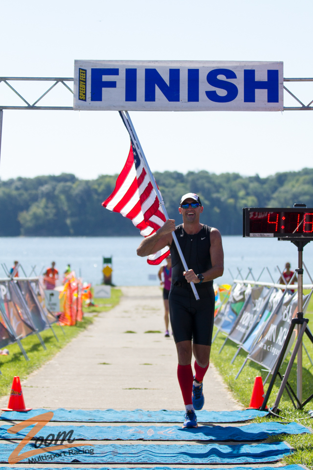Athlete Finish Triathlon Race with American Flag